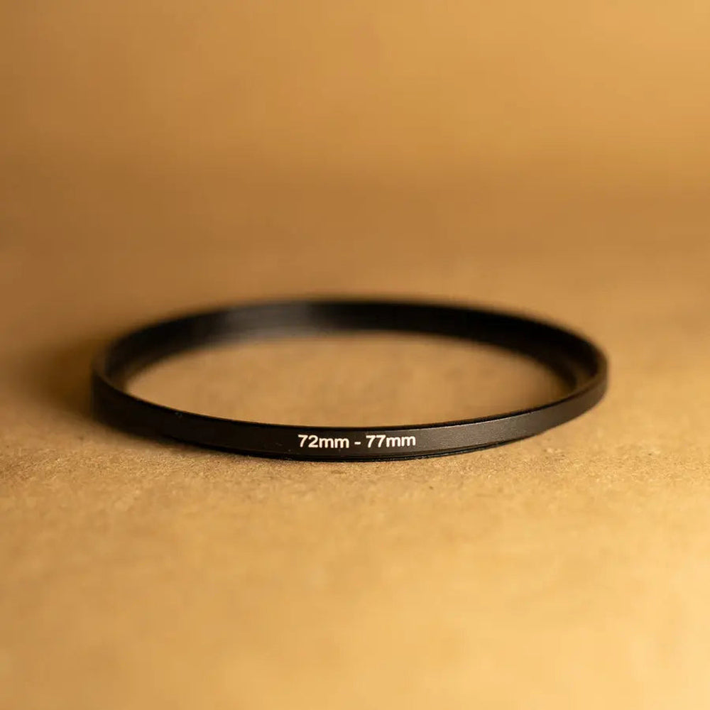 Representative photo of black CNC metal 72mm-to-77mm filter step-up ring, size marked 72mm–77mm; confirm exact TEKTONIC SKU appearance before publishing