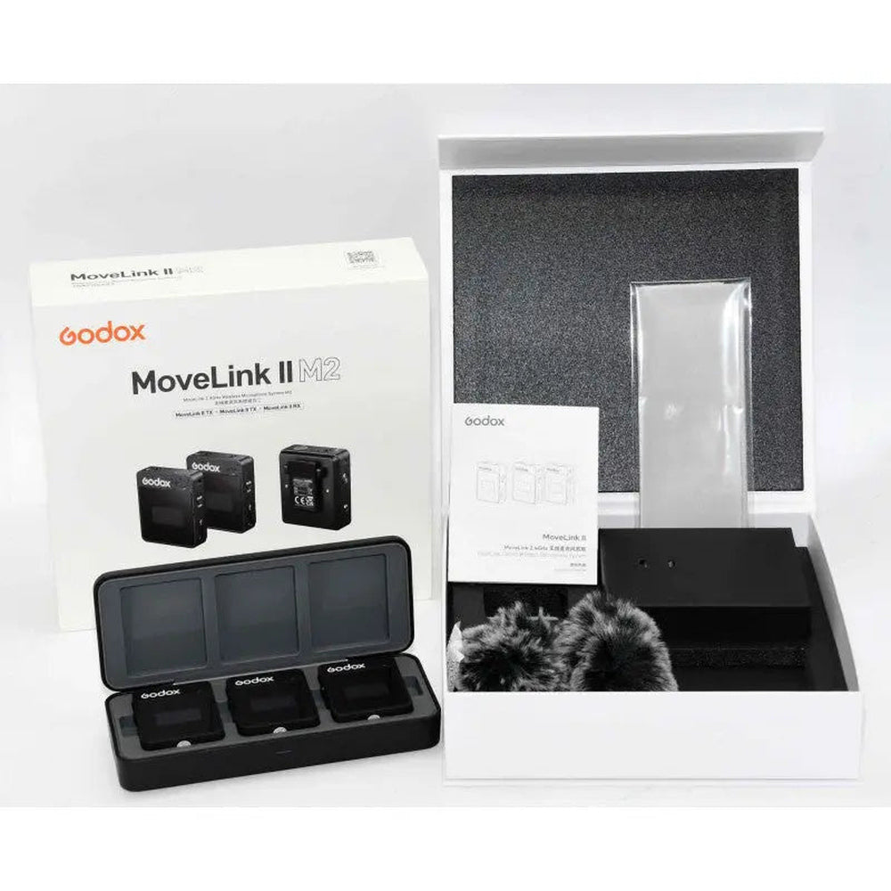 Godox MoveLink II M2 two-person wireless microphone charging case and three units beside original retail box