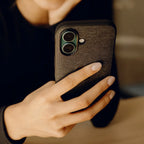 Peak Design Everyday Fabric Case for iPhone 16 – Charcoal lifestyle view in hand